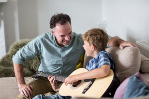 Son playing guitar with Father