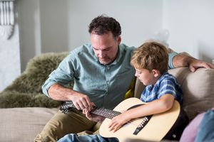 Father teaching son guitar chords