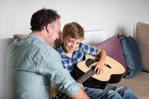 Son playing guitar with Father
