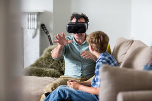 Father using a VR headset game at home
