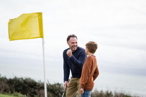 Father celebrating with son on golf course