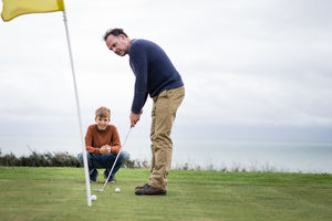 Son watching Father play golf