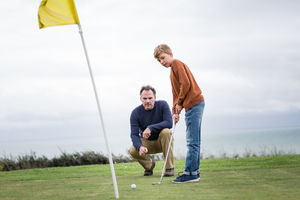 Father watching Son play golf
