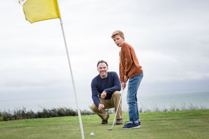 Father watching Son play golf