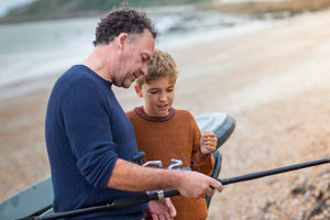 Father and Son setting up a fishing rod together