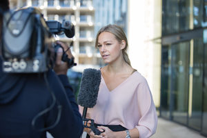 News presenter reporting to camera