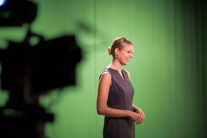 Presenter standing in a green screen studio