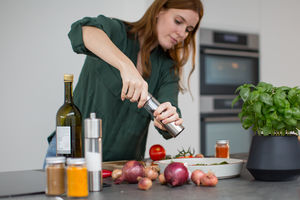 Adult female seasoning a dish