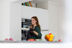 Adult female taking dish out of oven