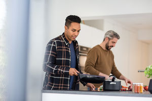 Adult male friends preparing a meal together
