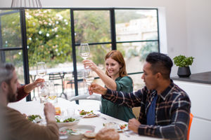 Friends clinking glasses over a meal together