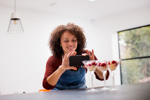 Female food blogger taking a photo with smartphone