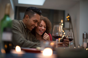 Couple looking at smartphone together at a meal
