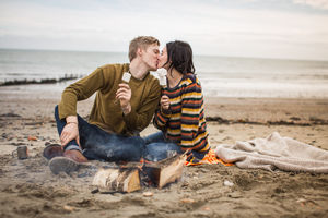 Young couple kissing by camp fire