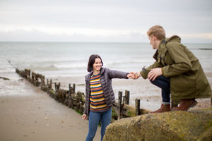 Boyfriend helping girlfriend climb a rock