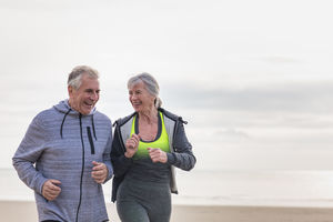 Senior couple jogging on beach