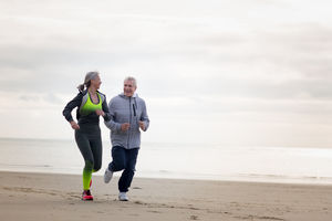 Senior couple jogging on beach