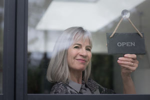Senior businesswoman opening shop