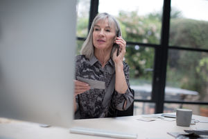 Senior businesswoman working in office using smartphone