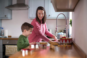 Mother and Son baking cookies in kitchen