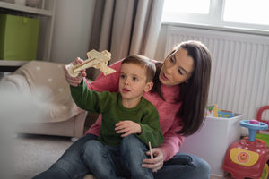 Mother and Son playing with toy model plane