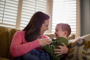 Mother tickling Son on sofa