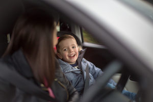 Boy smiling at Mother on car road trip
