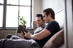 Young male couple looking at smarphone together