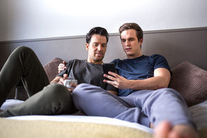 Young male couple looking at smarphone together