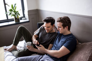 Young male couple looking at smarphone together