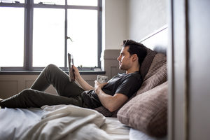 Young male reading on digital tablet