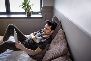 Young male reading on digital tablet