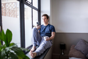 Young male with smartphone and coffee