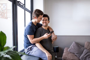 Young male couple making plans with smartphone
