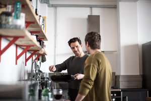 Young male couple cooking in kitchen