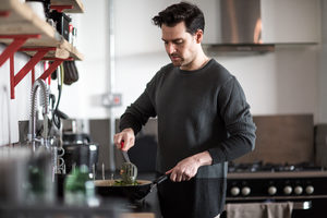Young male cooking in kitchen