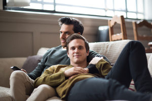 Portrait of young male couple relaxing on sofa