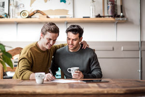Young male couple signing legal document