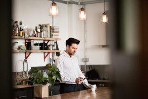 Businessman checking smartphone at home