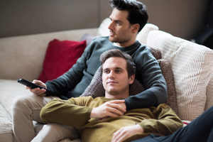 Young male couple relaxing on sofa