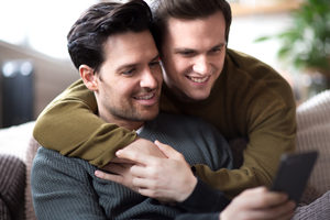 Young male couple with smartphone making plans