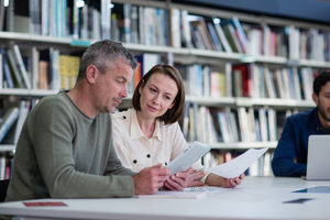 Mature students in library studying together