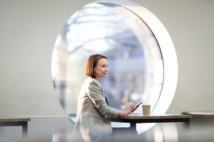 Businesswoman waiting in cafe checking smartphone
