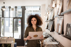 Young Adult female holding record in a store