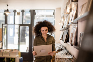 Young Adult female holding record in a store