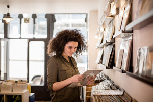 Young Adult female holding record in a store