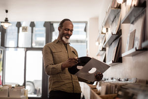 Senior male holding a record in a store