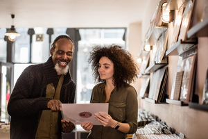 Store owner helping customer in a record store