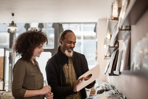 Store owner helping customer in a record store