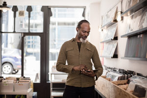 Small business owner using digital tablet in a record store